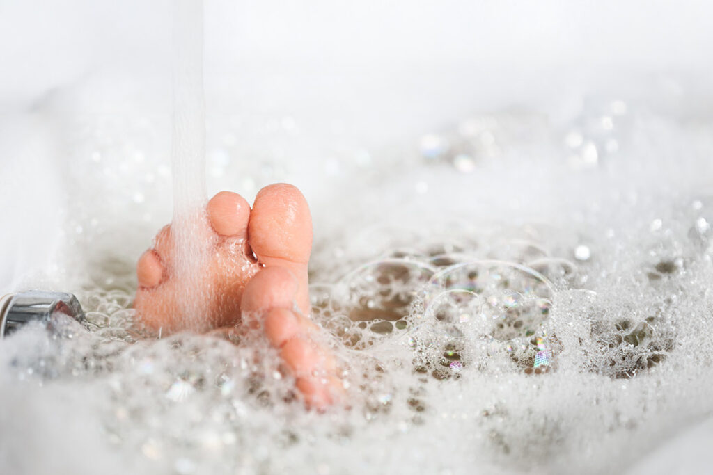 Feet relaxing in a warm, soapy bubble bath.